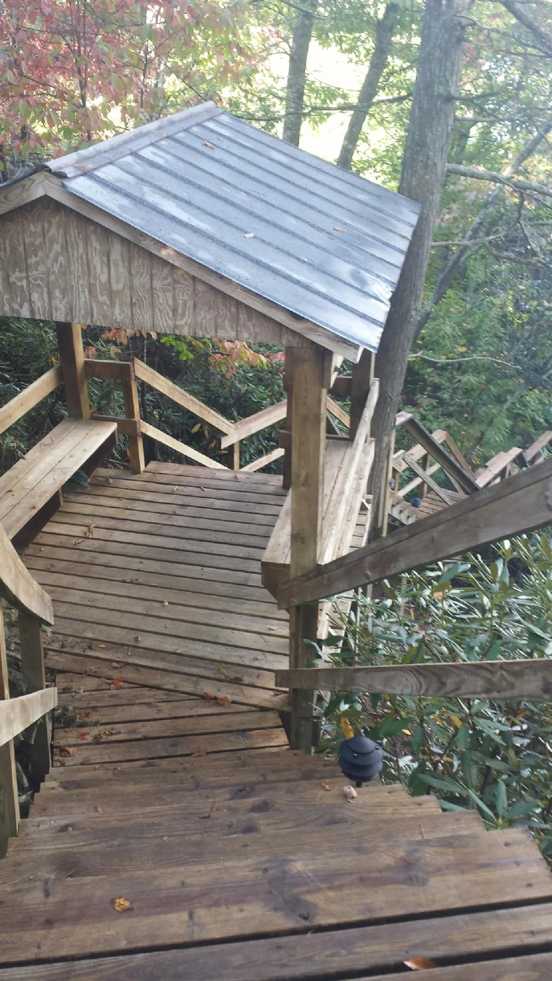 Metal roofed shelter over wooden steps on a wooded walkway — Skylight Repair & Installation work by our crew in Bouckville